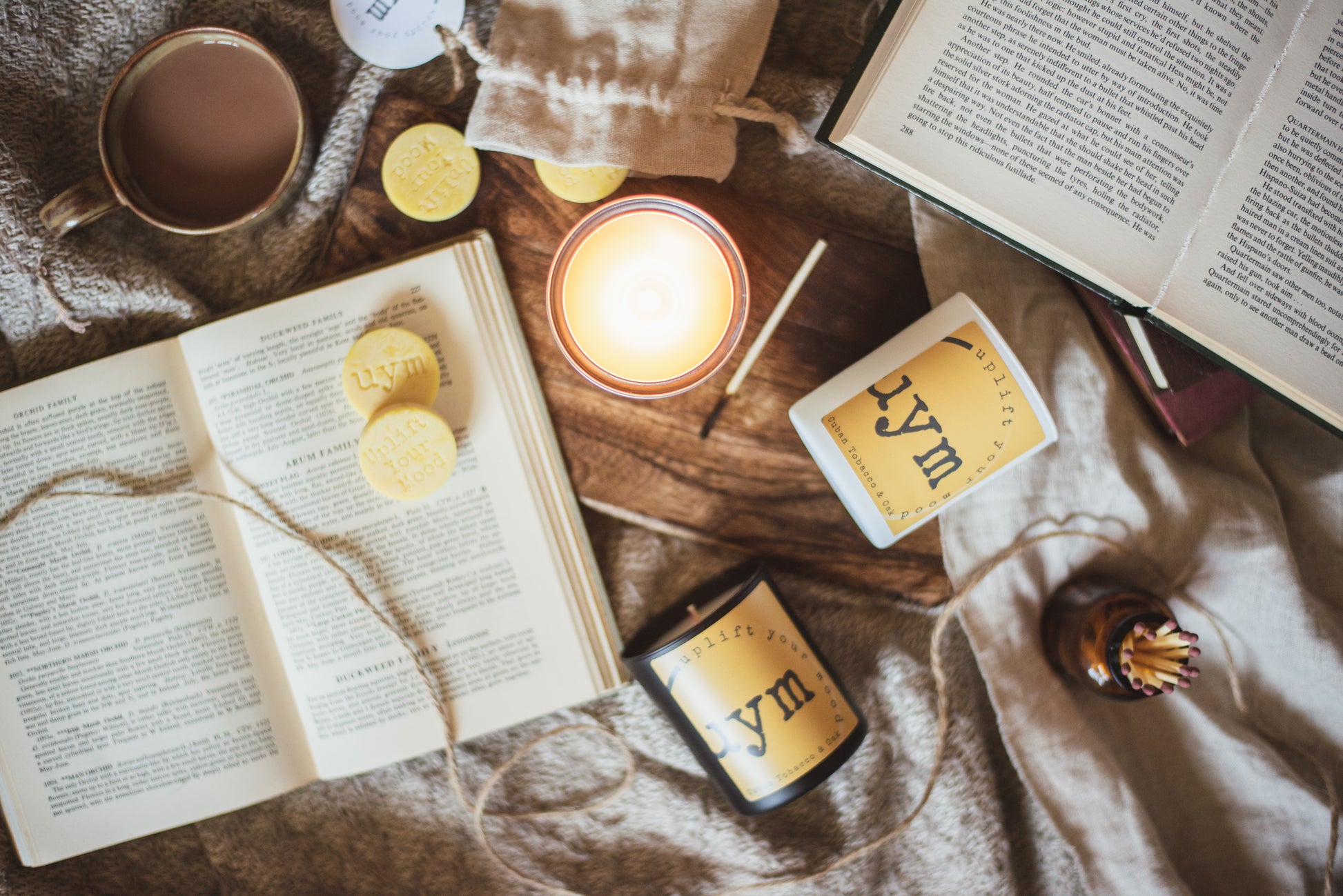 Cuban Tobacco & Oak Candle, highly scented natural wax candle and wax melts, lighted metallic tin candle, books.  cosy background, Uplift Your Mood Scents